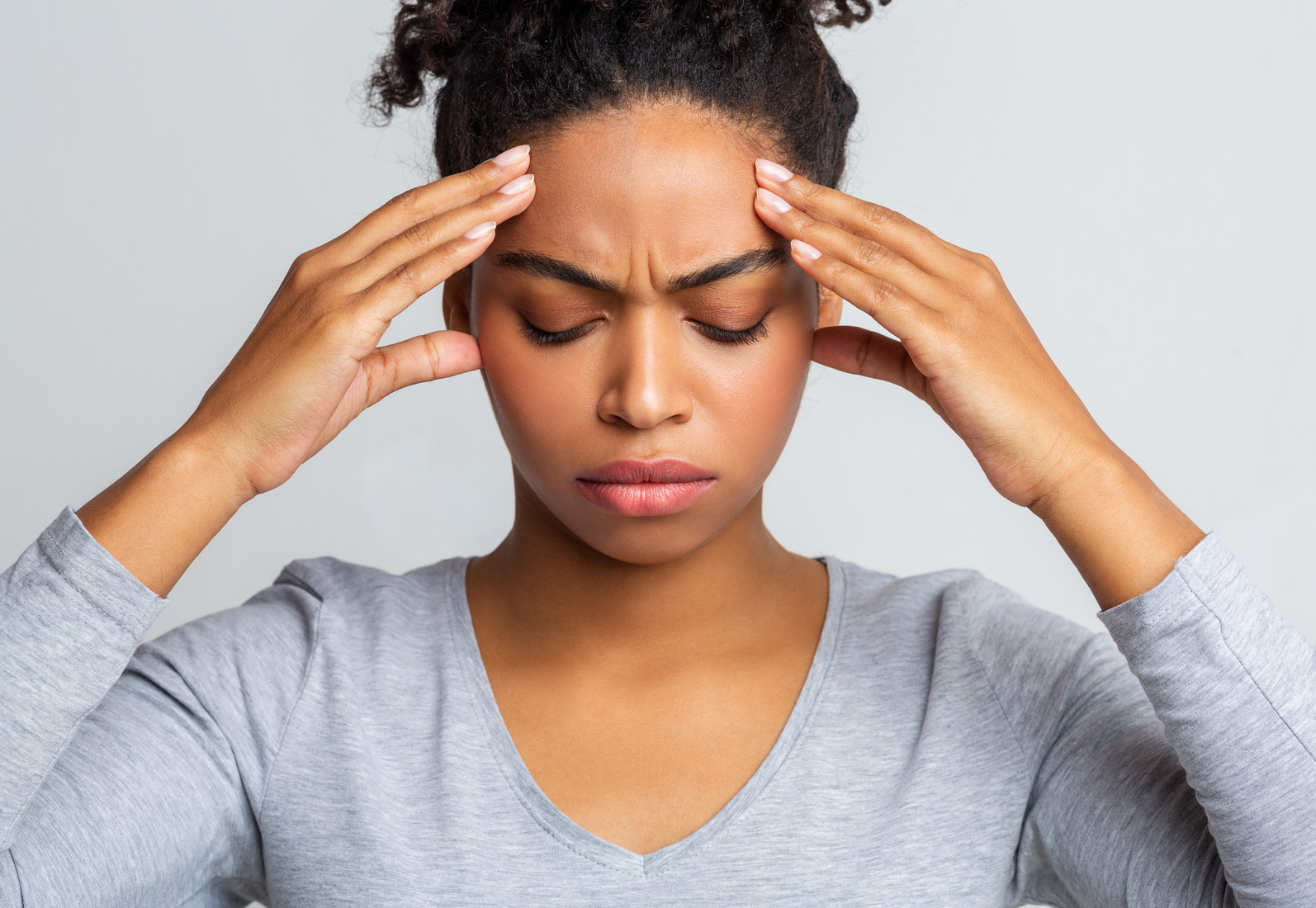 Sad black woman having headache, touching her temples